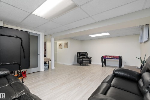 Spacious recreation room featuring light wood-finish flooring, recessed lighting, and a drop ceiling - 17 Camelot Avenue, Leduc, AB - Indoor Photo Showing Basement
