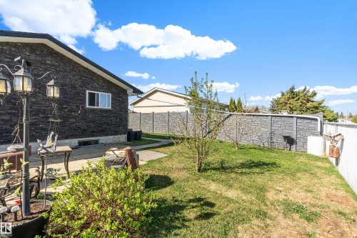 Exterior featuring dark stacked stone siding, white trim, and a white window - 17 Camelot Avenue, Leduc, AB - Outdoor