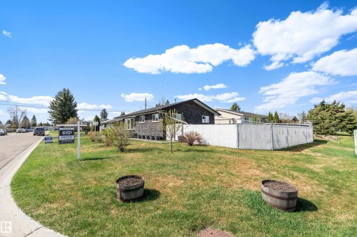 Exterior featuring a dark brick facade, white trim, and a white lattice fence - 17 Camelot Avenue, Leduc, AB - Outdoor