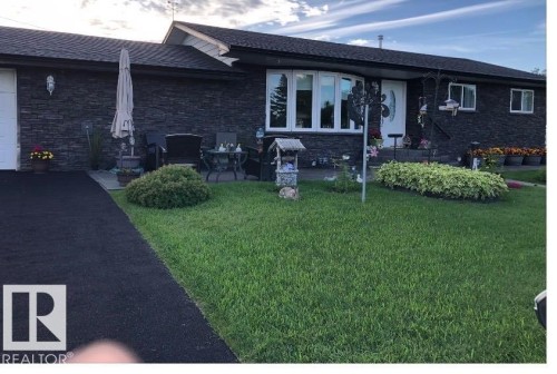 Exterior with dark stacked stone siding, a curved bay window, and a white entry door - 17 Camelot Avenue, Leduc, AB - Outdoor