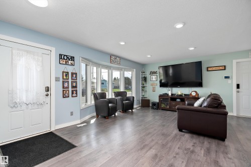 Spacious living area featuring wood-finish flooring, recessed lighting, and a prominent bay window - 17 Camelot Avenue, Leduc, AB - Indoor Photo Showing Living Room