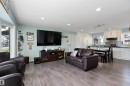 Open-concept living space featuring wood-finish flooring, recessed lighting, and a white kitchen with shaker cabinetry - 17 Camelot Avenue, Leduc, AB  - Indoor Photo Showing Living Room 