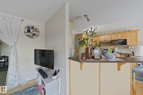 The property features a kitchen with light wood cabinetry, a microwave, and a stainless steel range hood - 3120 25 Avenue Nw, Edmonton, AB - Indoor Photo Showing Kitchen