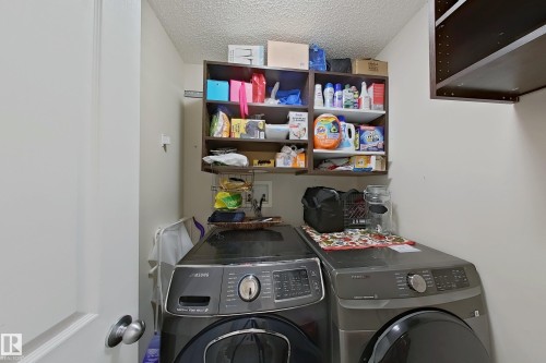 Dedicated laundry area featuring overhead shelving and space for appliances - 3120 25 Avenue Nw, Edmonton, AB - Indoor Photo Showing Laundry Room