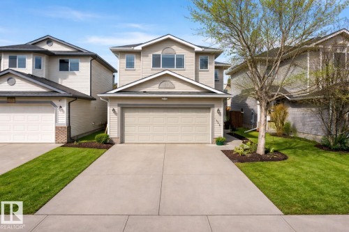 The property features a two-story exterior with light-colored siding, a dark roof, and an integrated garage - 3120 25 Avenue Nw, Edmonton, AB - Outdoor With Facade