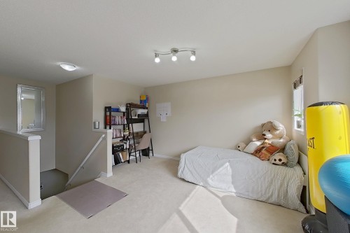 This versatile space features carpeting, a window providing natural light, and a functional overhead track light fixture - 3120 25 Avenue Nw, Edmonton, AB - Indoor Photo Showing Bedroom