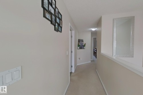 The property features a hallway with light-colored walls and carpeted flooring - 3120 25 Avenue Nw, Edmonton, AB - Indoor Photo Showing Other Room