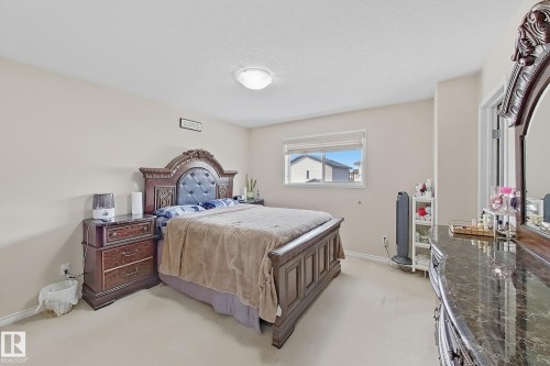 This room features light-colored walls and carpeting, a window providing natural light, and a ceiling light fixture - 3120 25 Avenue Nw, Edmonton, AB - Indoor Photo Showing Bedroom