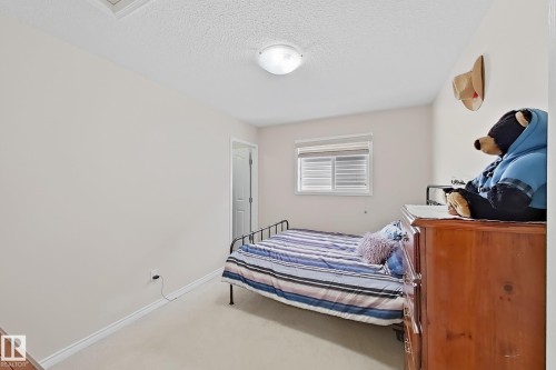 This room features light-colored walls, a ceiling light fixture, and a window with blinds - 3120 25 Avenue Nw, Edmonton, AB - Indoor Photo Showing Bedroom