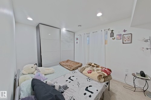 This room features white walls, recessed lighting, and a window with blinds and white curtains - 3120 25 Avenue Nw, Edmonton, AB - Indoor Photo Showing Bedroom