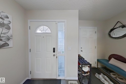 Entryway featuring a white paneled door with an arched window, a full-length sidelight, and light-colored walls - 3120 25 Avenue Nw, Edmonton, AB - Indoor Photo Showing Other Room