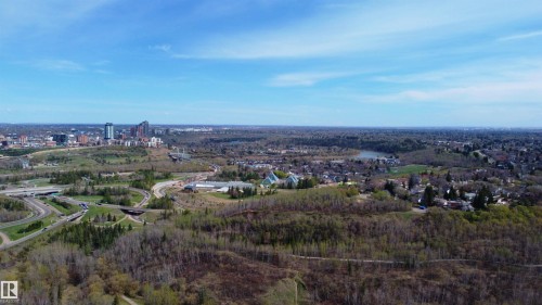 Expansive aerial perspective showcasing a cityscape with multiple high-rise buildings, extensive green spaces, and a river winding through the landscape - 101 9131 99 Street, Edmonton, AB - Outdoor With View