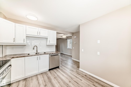 Kitchen featuring white cabinetry, subway tile backsplash, and stainless steel dishwasher - 2578 138A Avenue, Edmonton, AB - Indoor Photo Showing Kitchen With Double Sink