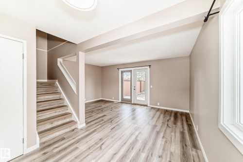 Spacious living area featuring wood-finish flooring, neutral wall paint, and a vaulted ceiling - 2578 138A Avenue, Edmonton, AB - Indoor Photo Showing Other Room