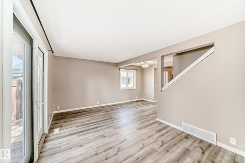 Spacious living area featuring wood-finish flooring, neutral wall tones, and white trim - 2578 138A Avenue, Edmonton, AB - Indoor Photo Showing Other Room