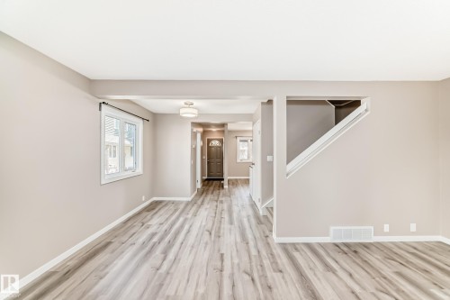 Spacious interior featuring wide plank wood-finish flooring, neutral wall tones, and white trim - 2578 138A Avenue, Edmonton, AB - Indoor Photo Showing Other Room