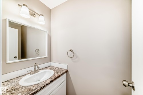 Bathroom vanity featuring an integrated oval sink, a patterned countertop, and a white base cabinet - 2578 138A Avenue, Edmonton, AB - Indoor Photo Showing Bathroom
