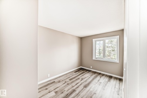 Room featuring warm neutral wall tones, white trim, and wood-finish flooring - 2578 138A Avenue, Edmonton, AB - Indoor Photo Showing Other Room