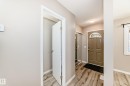 Entryway featuring wood-finish flooring, a paneled front door with an arched transom, and a mirrored sliding closet door - 2578 138A Avenue, Edmonton, AB  - Indoor Photo Showing Other Room 