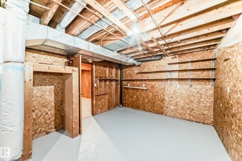 Unfinished basement space featuring exposed wood joists and subflooring, concrete flooring, and built-in shelving - 2578 138A Avenue, Edmonton, AB - Indoor Photo Showing Basement
