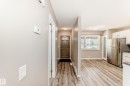 Entryway featuring wood-finish flooring, a contemporary front door with an arched glass insert, and a modern thermostat - 2578 138A Avenue, Edmonton, AB  - Indoor 