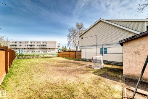 Expansive backyard with a mix of grass and natural ground cover, featuring a new wood fence on two sides - 2578 138A Avenue, Edmonton, AB - Outdoor