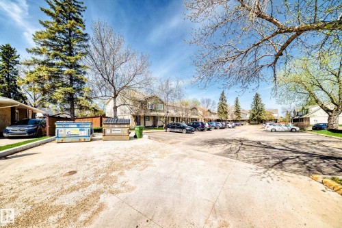 Paved parking area with mature trees and surrounding multi-unit residential buildings - 2578 138A Avenue, Edmonton, AB - Outdoor