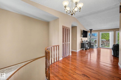 Open concept living area featuring wood-finish flooring, a vaulted ceiling, and a prominent wood-burning stove - 250 197 Avenue, Edmonton, AB - Indoor Photo Showing Other Room