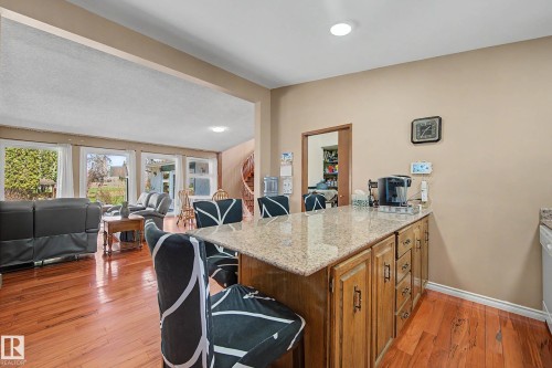 Kitchen island featuring a light-toned countertop and wood-finish cabinetry - 250 197 Avenue, Edmonton, AB - Indoor