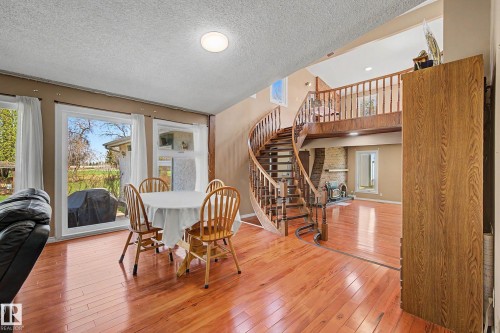 Open concept interior featuring wood-finish flooring and a spiraling wooden staircase - 250 197 Avenue, Edmonton, AB - Indoor Photo Showing Dining Room