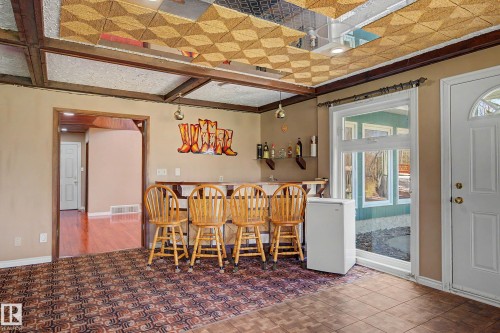 Finished basement space featuring a built-in wet bar, patterned carpet, and tiled flooring - 250 197 Avenue, Edmonton, AB - Indoor Photo Showing Other Room