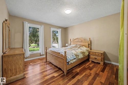 Bedroom featuring wood-finish flooring, neutral wall paint, and two windows with white trim - 250 197 Avenue, Edmonton, AB - Indoor Photo Showing Bedroom