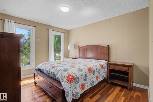 Room featuring wood-finish flooring, two large windows with white trim, and neutral-toned walls - 250 197 Avenue, Edmonton, AB - Indoor Photo Showing Bedroom
