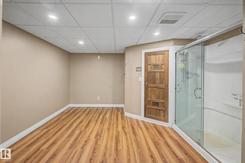 Spacious area featuring wood-finish flooring, recessed ceiling lights, and a drop ceiling - 250 197 Avenue, Edmonton, AB - Indoor
