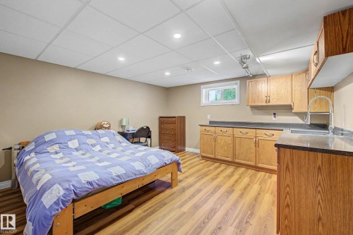 Spacious room featuring wood-finish flooring and a drop ceiling with recessed lighting - 250 197 Avenue, Edmonton, AB - Indoor