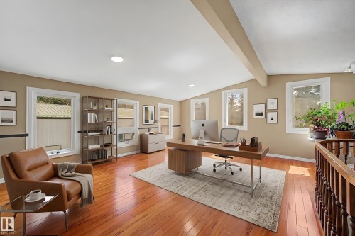 Spacious room featuring rich wood-finish flooring, multiple windows, recessed lighting, and exposed ceiling beams - 250 197 Avenue, Edmonton, AB - Indoor Photo Showing Office