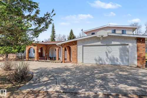 Concrete driveway leading to a two-car garage with a white sectional door - 250 197 Avenue, Edmonton, AB - Outdoor