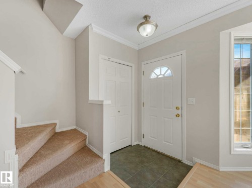 Entryway featuring a decorative front door with an arched window, a flush mount ceiling light, and tile flooring - 17 15128 22 Street, Edmonton, AB - Indoor Photo Showing Other Room