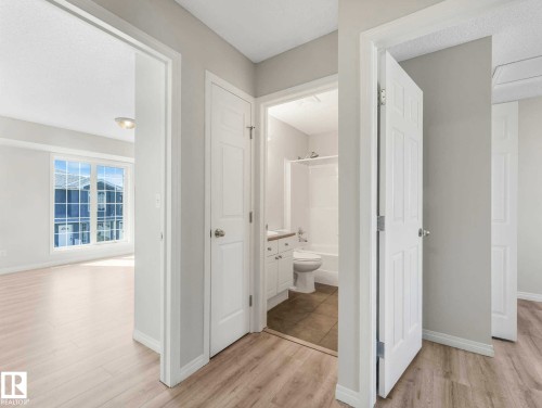 Clean hallway featuring light wood-finish flooring and neutral wall tones - 17 15128 22 Street, Edmonton, AB - Indoor
