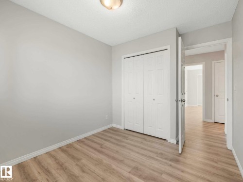 Room featuring wood-finish flooring, light gray wall paint, and white baseboards - 17 15128 22 Street, Edmonton, AB - Indoor Photo Showing Other Room