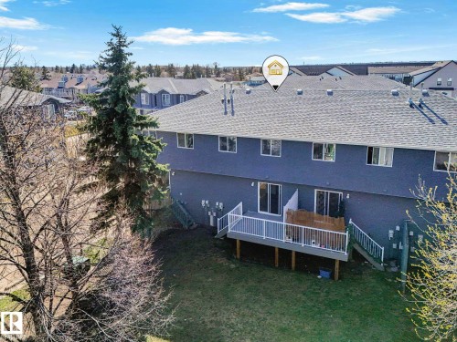 Rear elevation featuring grey siding, a shingled roof, and multiple windows - 17 15128 22 Street, Edmonton, AB - Outdoor