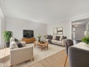 Spacious living area featuring light wood-finish flooring, white crown molding, and neutral wall tones - 17 15128 22 Street, Edmonton, AB  - Indoor Photo Showing Living Room 