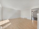 Spacious interior featuring light wood-finish flooring, white baseboards, and white crown molding - 17 15128 22 Street, Edmonton, AB  - Indoor Photo Showing Other Room 