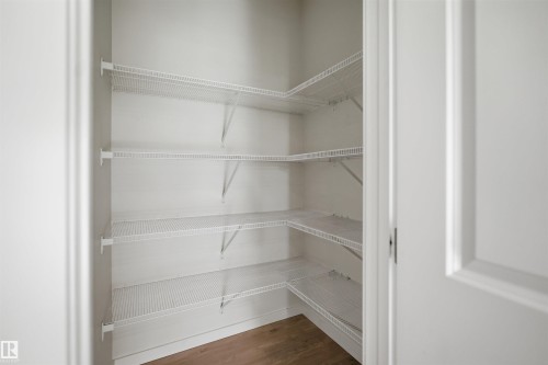 Pantry featuring wire shelving and wood flooring - 2125 Maple Road Nw, Edmonton, AB - Indoor With Storage