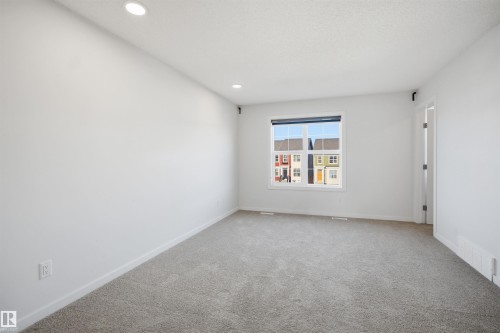Room featuring neutral tone carpet, white walls, and recessed lighting - 2125 Maple Road Nw, Edmonton, AB - Indoor Photo Showing Other Room