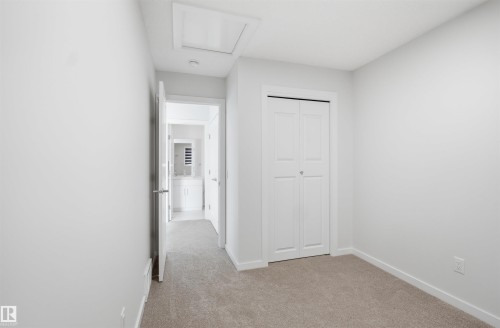 Room featuring light gray walls, gray carpet, and a white bi-fold closet door - 2125 Maple Road Nw, Edmonton, AB - Indoor Photo Showing Other Room