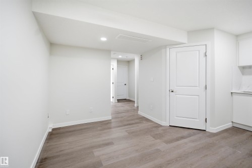Spacious room with light wood-style flooring, white walls, and recessed lighting - 2125 Maple Road Nw, Edmonton, AB - Indoor Photo Showing Other Room