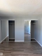 Bedroom featuring wood-finish flooring, light gray wall paint, and white trim - 