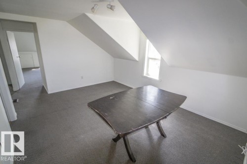 Attic room featuring a single window, track lighting, and grey carpet flooring - 4814 51 Ave, St. Paul Town, AB - Indoor Photo Showing Other Room