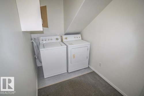 Dedicated laundry area with a washer and dryer, white cabinetry, and mixed flooring - 4814 51 Ave, St. Paul Town, AB - Indoor Photo Showing Laundry Room